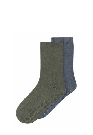Deux paires de chaussettes montantes côtelées en olive et bleu, chacune avec des picots en caoutchouc antidérapants sous la semelle.