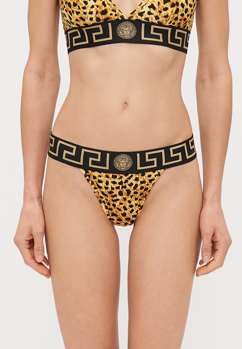 Leoparda raksta bikini komplekts ar melnu jostu, kas satur zelta akcentus un grieķu atslēgas rakstu. Materiāls izskatās gluds un elastīgs.