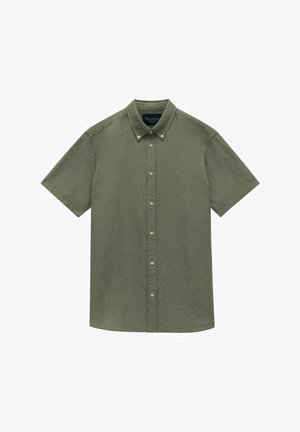 Chemise à manches courtes et à boutons de couleur olive, fabriquée en tissu texturé, avec un col et des boutons contrastants sur le devant.