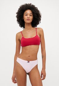 Rode katoenen bralette met dunne bandjes en logoprint, gecombineerd met lichtroze katoenen bikini-onderbroekjes met een label op de tailleband.
