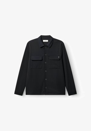 Schwarze Langarmhemdjacke mit spitzem Kragen, durchgehender Knopfleiste und zwei Brustklappentaschen, auf weißem Hintergrund flach ausgebreitet.