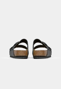 Sandali aperti neri con sottopiede in sughero, suola in gomma e doppie fibbie con decorazioni.