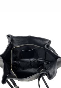 Černá kožená taška přes rameno s texturovaným povrchem. Má zapínání na zip, textilní podšívku a vnitřní kapsu na drobné předměty.