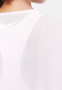Pink Nike activewear top, featuring a lightweight, sheer texture with a rounded neckline and subtle logo, designed for comfort and breathability.