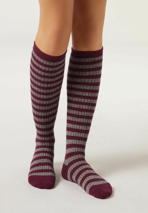 Calcetas hasta la rodilla en burdeos y gris con rayas verticales alternas. Hechas de un material suave y texturizado, adecuado para un uso casual.
