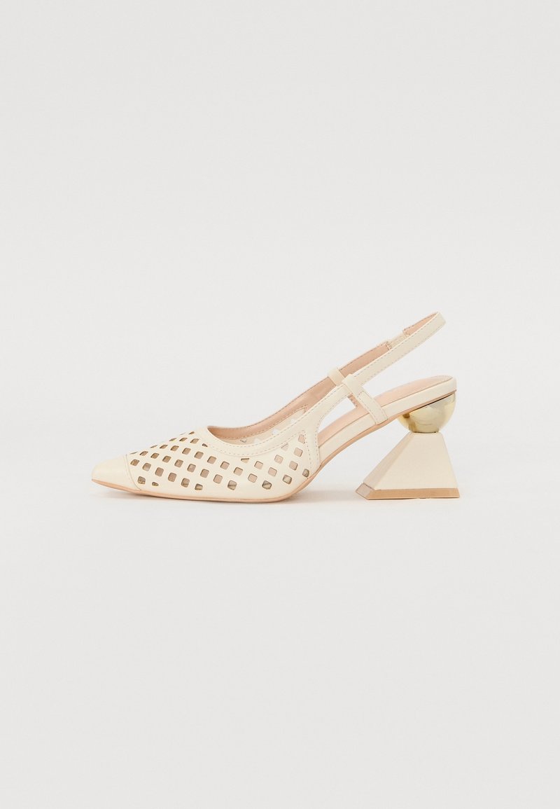 Chaussure beige à bride arrière avec motif carré découpé à l'avant et talon géométrique combinant une sphère dorée et une large forme trapézoïdale.