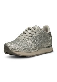 Silver glitter idrottssko med rund tå, snörning framtill och en beige sula. Texturerad yta med reflekterande detaljer och en vadderad krage.