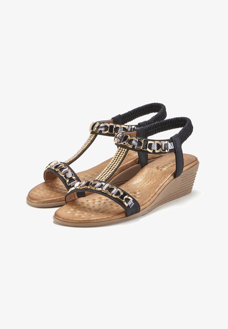 Sandalias de cuña negras con plantilla dorada texturizada, detalles de cadena y correas elásticas para un ajuste seguro. Plantilla acolchada para mayor comodidad.