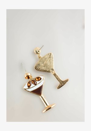 Gold-tone earrings shaped like cocktail glasses, featuring a white and brown enamel design with brown gem accents, exhibiting a textured finish.