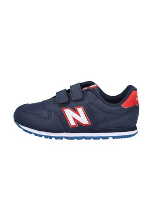 Zapatilla azul marino con correas de velcro, acentos en blanco y rojo, suela de goma, detalles de tela de malla y logo de New Balance en el costado.