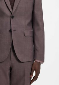 Dunkel malvenfarbener Anzugsakko mit dezent strukturierter Stoff, Ein-Knopf-Verschluss und gekerbten Revers. Mit Vordertaschen und figurbetontem Schnitt.