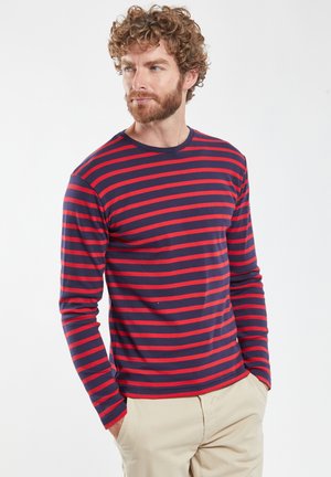 Chemise à manches longues bleu marine avec des rayures horizontales rouges. Dotée d'un col rond et d'un tissu doux et texturé. Coupe classique.