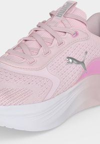 Ανοιχτό ροζ αθλητικό παπούτσι Puma με ύφασμα διχτυού, λαστιχένια σόλα, ροζ κορδόνια και ασημί λογότυπο Puma στο πλάι.