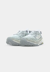 Light blue trail running shoes with textured mesh upper, cushioned midsole, and rugged outsole featuring a visible Vibram logo.