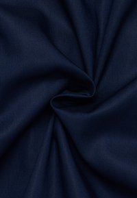 Navyblauwe stof met een gladde textuur, voorzien van een licht glanzende afwerking en een zachte val, gerangschikt in plooien.