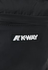 Tessuto di nylon nero con una leggera trama, con una patche logo bianco K-Way e una cerniera nera lungo il bordo.
