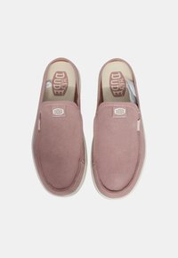Scarpe slip-on rosa chiaro con tomaia in morbido tessuto, suola in gomma bianca e etichetta con logo sul lato. Punta arrotondata e dettagli di cucitura minimi.
