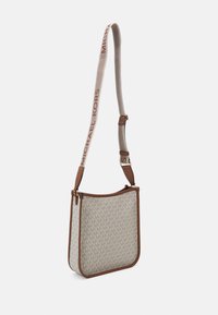 Michael Kors skuldertaske i creme med et gentaget logomønster, brun lædertrim og en beige justerbar rem med logo.