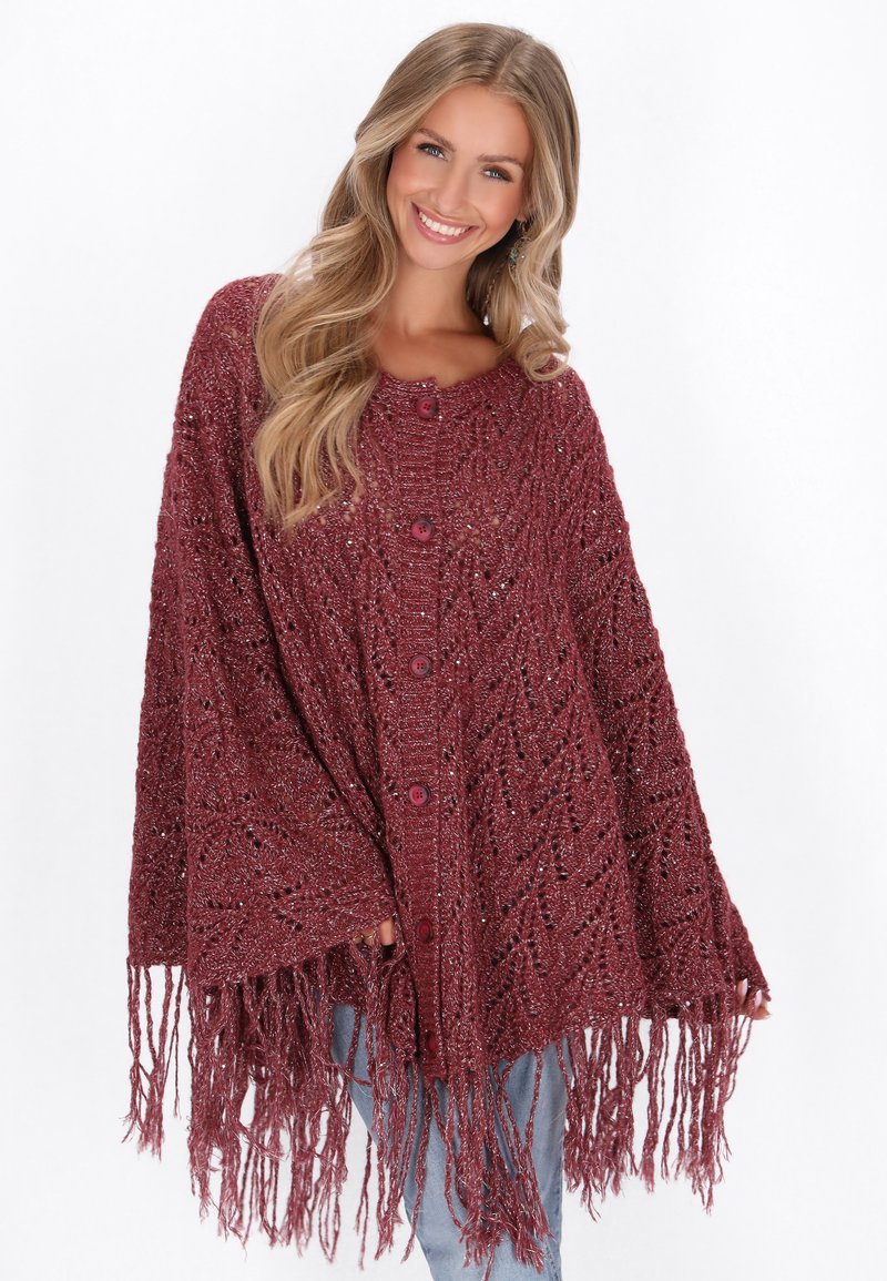 Poncho tricoté en bordeaux avec un motif texturé, doté d'un col rond, de boutons à l'avant et de longues franges à l'ourlet.