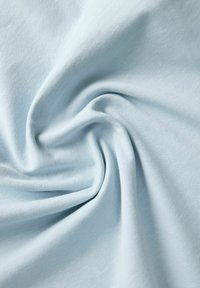 Tela de algodón azul claro, con textura suave, finamente estriada y pliegues que caen, mostrando un suave brillo y una sutil variación de color.