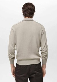 Light grey sweater with a round neck, ribbed cuffs, and hem. The fabric appears soft and knitted, with a smooth, even texture.