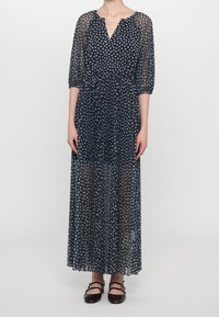 Robe maxi florale marine avec des manches trois-quarts en transparent, un décolleté en V et une taille froncée, arborant un délicat motif de fleurs blanches.