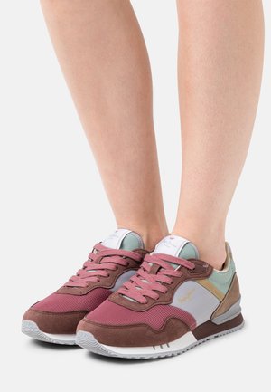 Zapatillas deportivas en marrón y gris, con materiales de malla y ante, que presentan detalles en tonos pastel y cierre de cordones, montadas sobre una suela de goma blanca.