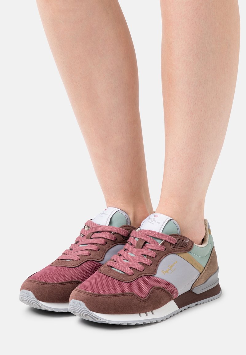 Bordeaux- ja harmaat urheilukengät, joissa on verkkokangas- jaNUDE- materiaalia, pastelliväriset yksityiskohdat ja nauhaketju, valkoisen kumipohjan päällä.