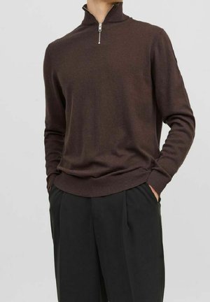Brązowy sweter na zamek z miękkiego materiału, z długimi rękawami i żebrowanym dołem, w połączeniu z czarnymi eleganckimi spodniami.
