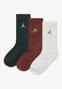 Tre paia di calze: verde scuro, borgogna e bianco. Ognuna presenta un logo Jumpman. La calza bianca ha una texture trapuntata.