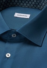 Teal overhemd van een gladde stof, met een puntige kraag en een gestikte zoom. Inclusief een logo-label en een gemusterde binnenkraag.