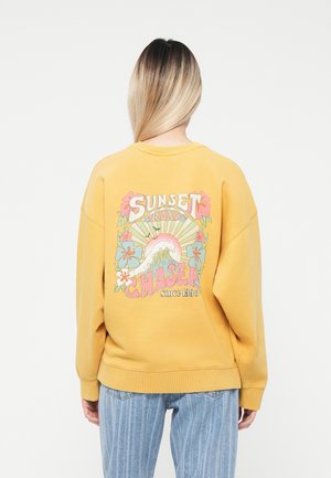 Geel sweatshirt met een kleurrijke grafische print op de achterkant met bloem- en golfontwerpen, geribbelde manchetten en een ronde hals.