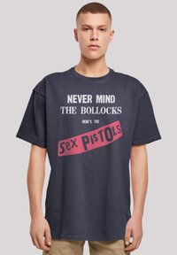 Navy blue t-shirt made of cotton featuring white and red printed text reading "Never Mind the Bollocks Here's the Sex Pistols."