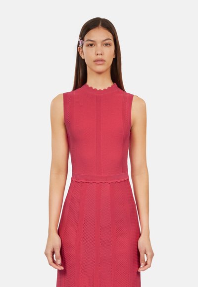 Robe sans manches rouge avec un col festonné et des motifs texturés. Présente un corsage ajusté et une jupe évasée. Fini en tissu lisse.