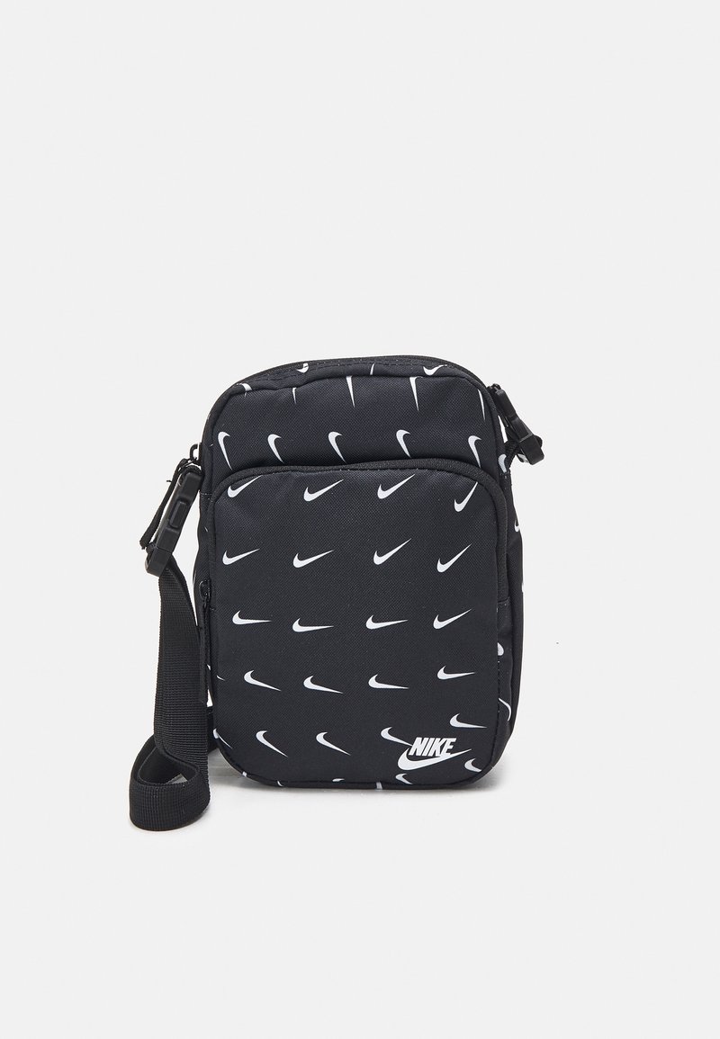 Svart tyg crossbody-väska med ett upprepat mönster av vita Nike-logotyper, dragkedjestängning och justerbar rem.