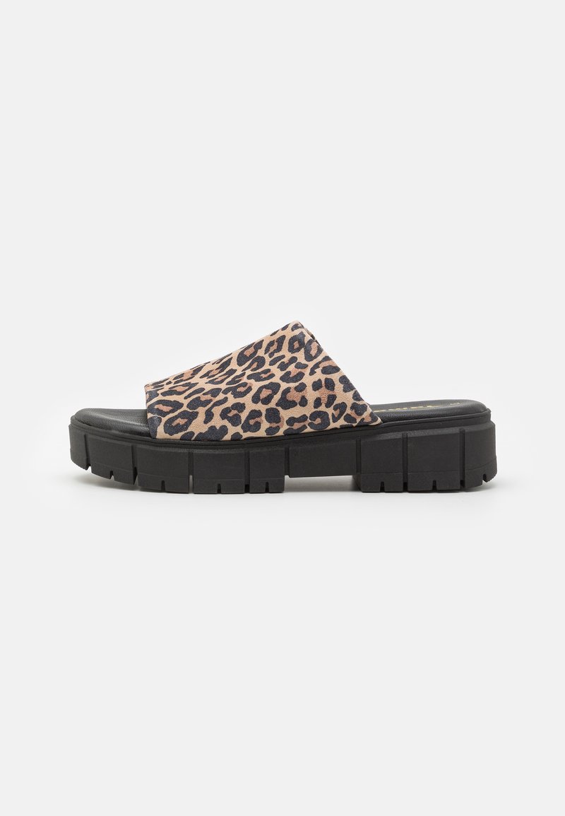 Sandaler med leopardmönster har ett mjukt ovandelsmaterial och en kraftig svart plattformssula med strukturerade gropar för grepp.