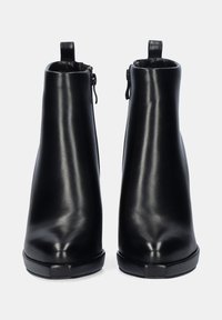 Botas de tobillo de cuero negro con una textura suave, punta redonda y cierre de cremallera en el lateral. Presentan una suela negra duradera y una pequeña lengüeta.