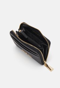 Black leather wallet with gold zipper, multiple compartments, and patterned interior. Features logo and smooth texture. Compact design.