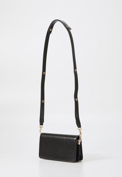Borsa a tracolla in pelle nera con forma rettangolare, design sottile, dettagli in metallo dorato e tracolla regolabile con borchie circolari.