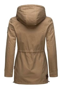 Veste brune avec une capuche, présentant un motif à pois, une taille élastique et des zips latéraux. Tissu texturé avec des accents de quincaillerie contrastants.
