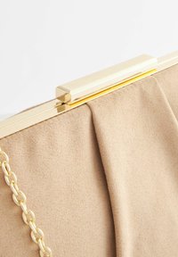 Beżowa materiałowa torebka kopertówka z złotym metalowym zapięciem i łańcuszkowym paskiem. Posiada karbowaną teksturę i gładką powierzchnię, co nadaje elegancki wygląd.
