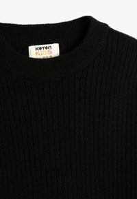 Czarny, prążkowany sweter z okrągłym dekoltem, wykonany z dzianiny. Posiada metkę z napisem "Koton Kids", rozmiar 116-122 cm.