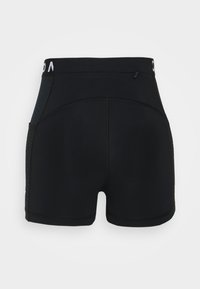 Musta urheilushortsit, joissa on korkea vyötärö, teksturoidut sivupaneelit, litteät saumat ja pieni vetoketjullinen tasku takana. Sileä, joustava kangas.