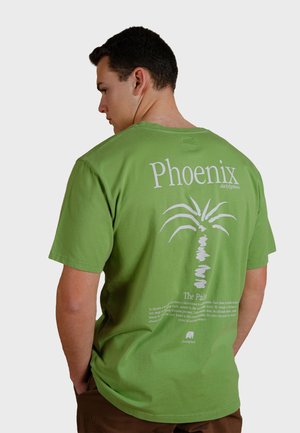 Green cotton t-shirt with a white palm tree graphic and text on the back. Short sleeves, crew neck, relaxed fit. Casual design.