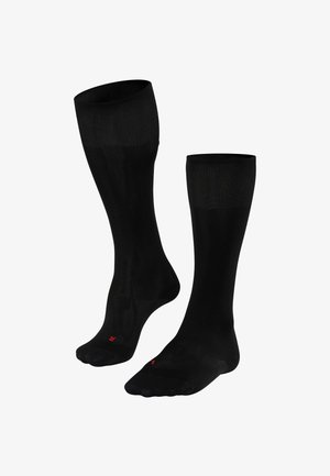 Black knee-high socks with a smooth texture, ribbed top, and a small red logo on the foot. Designed for comfort and durability.