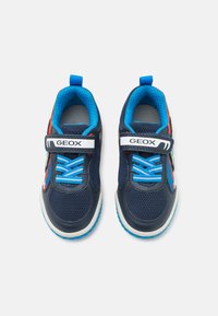 Blue mesh sneakers with navy accents, Velcro strap, and bright blue laces. Features a textured sole and multi-colored side detailing.