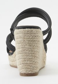 Sandalo con zeppa a righe nere, dotato di tacco in corda beige texturizzata, con tomaia in pelle liscia e una suola curva.