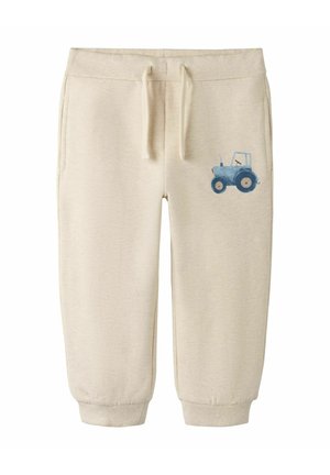 Béžové tepláky pre batoľa s nastaviteľným pásom na šnúrku, zakončené manžetami na členkoch, s bočnými vreckami a malou modrou grafikou traktora na pravom nohavici.