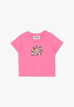 Chemise courte en coton rose avec un motif d'ours et le texte "MOSCHINO." Comprend une fermeture à pression à l'épaule pour un habillage facile.