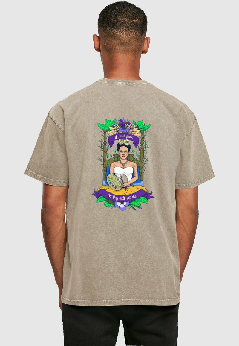 Beige cotton t-shirt featuring a colorful graphic of a woman in a white dress with a paint palette, surrounded by leaves and text.